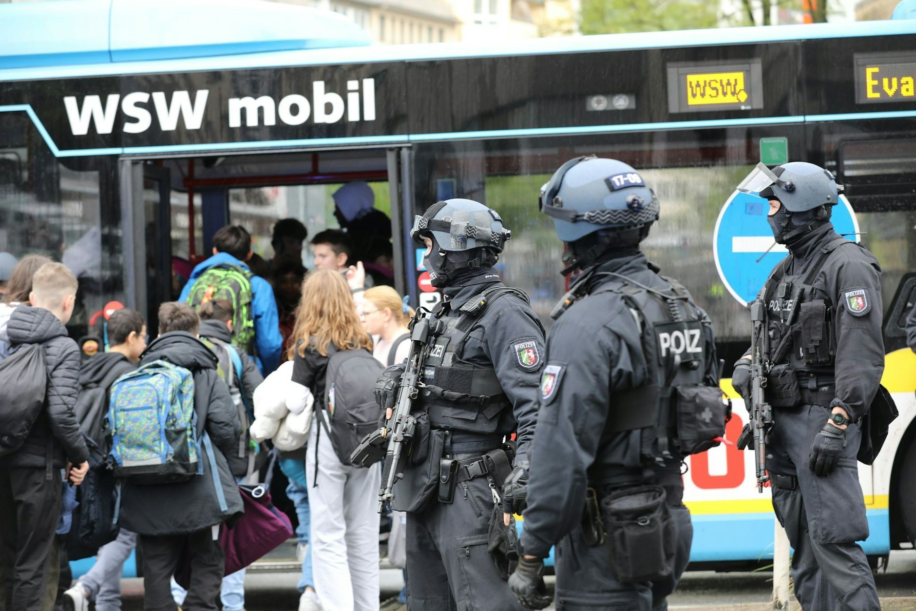 dpatopbilder - Polizisten führen Schüler in Wuppertal aus dem Gebäude in einen Evakuierungsbus.  