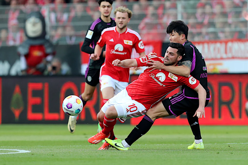 Bayern-Verteidiger Min-jae Kim klammert sich an Unions Kevin Volland fest.