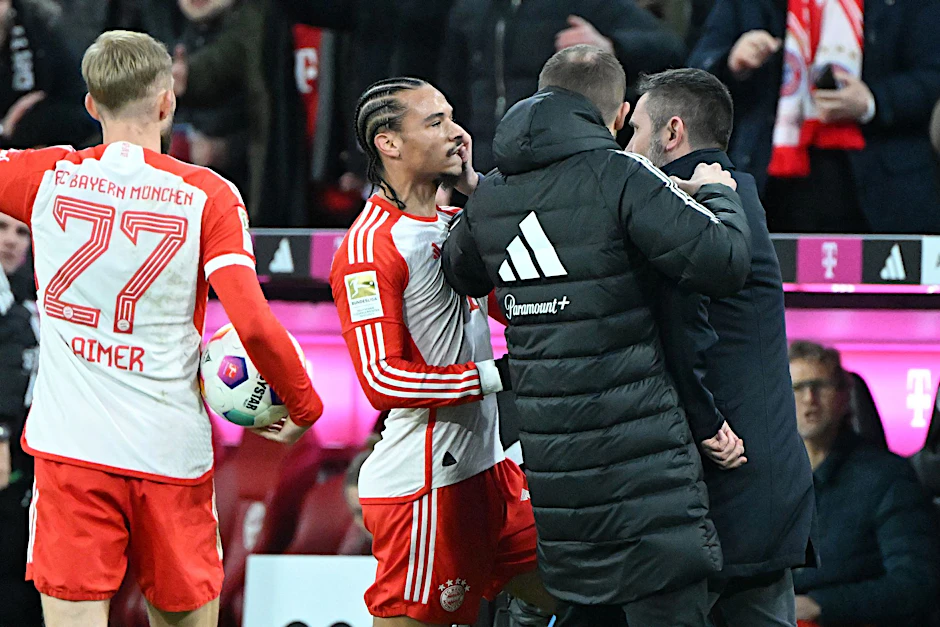 ARCHIV - Unions Trainer Nenad Bjelica (r) greift Bayern Münchens Leroy Sane (M) ins Gesicht.  