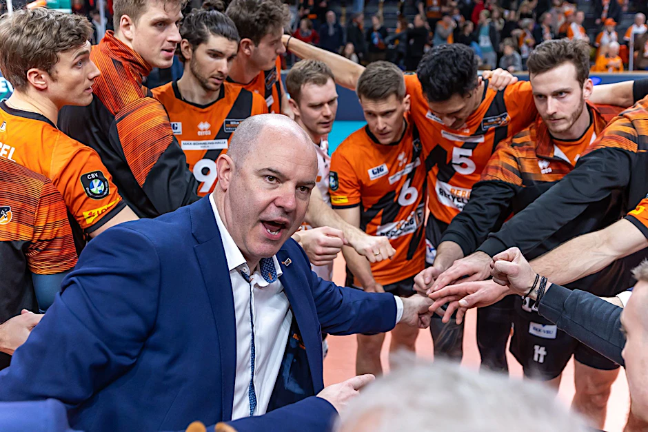 ARCHIV - Trainer Joel Banks der Berlin Volleys steht mit seinem Team zusammen und ruft etwas.  