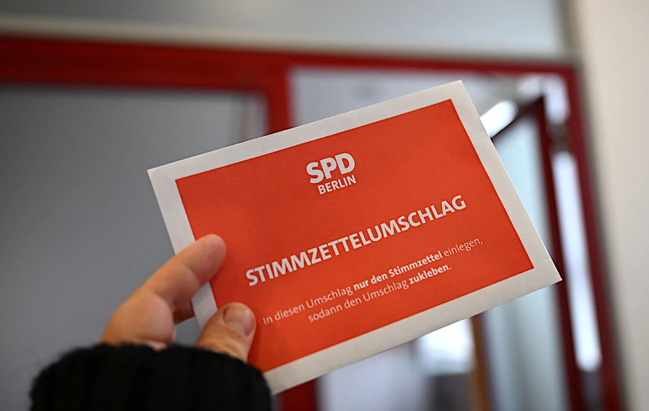 ILLUSTRATION - Ein Mann hält einen Stimmzettelumschlag in der Hand.  