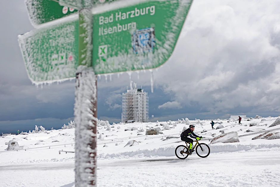 dpatopbilder - Ein Radfahrer ist auf dem schneebedeckten Brocken unterwegs.  