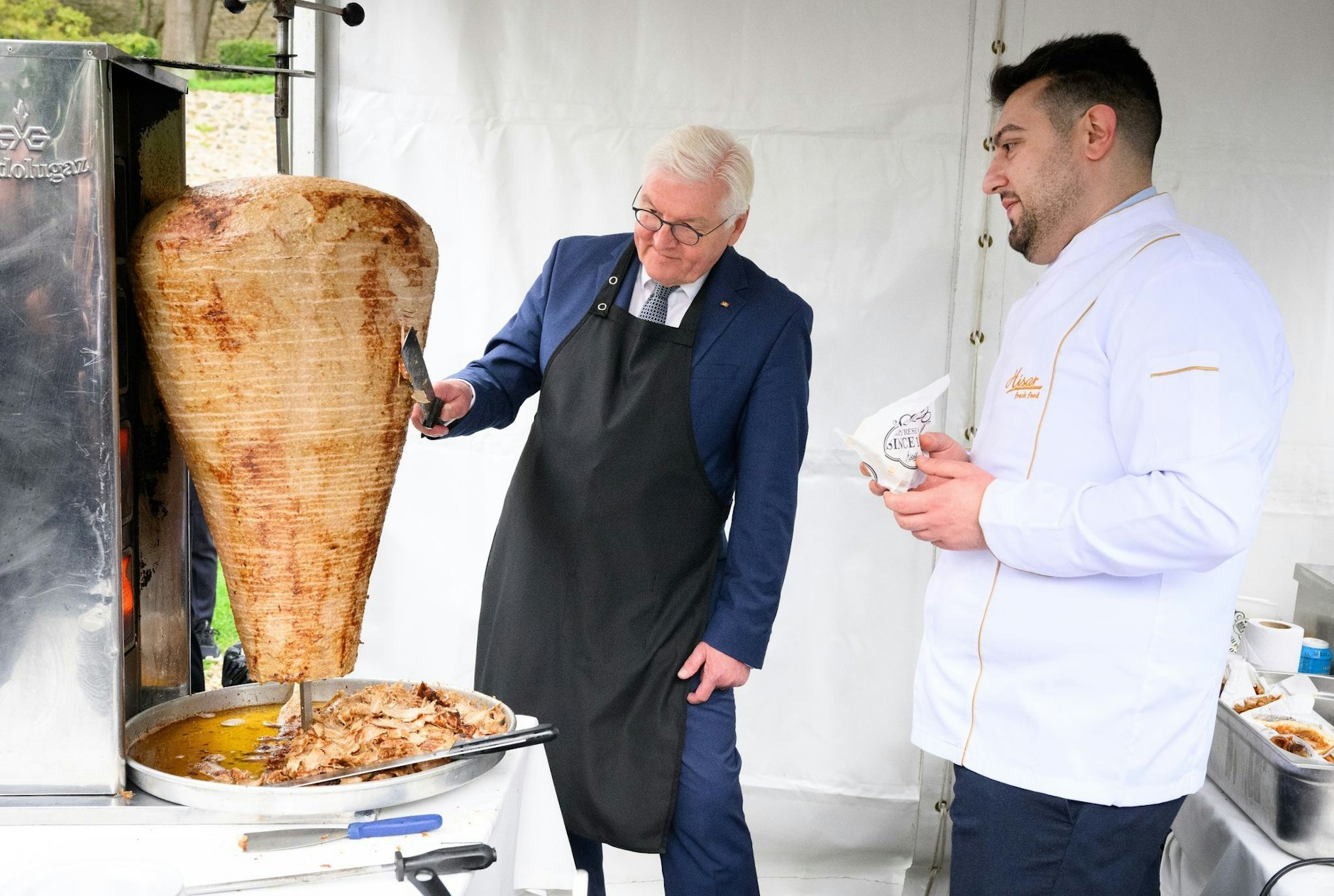 Bundespräsident Frank-Walter Steinmeier schneidet bei einem Empfang in der Sommerresidenz des deutschen Botschafters in Istanbul unter Anleitung des Berliner Gastronomen Arif Keles Dönerfleisch von einem Spieß. Keles wurde eingeladen, das deutsche Staatsoberhaupt auf seiner dreitägigen Reise in die Türkei zu begleiten.