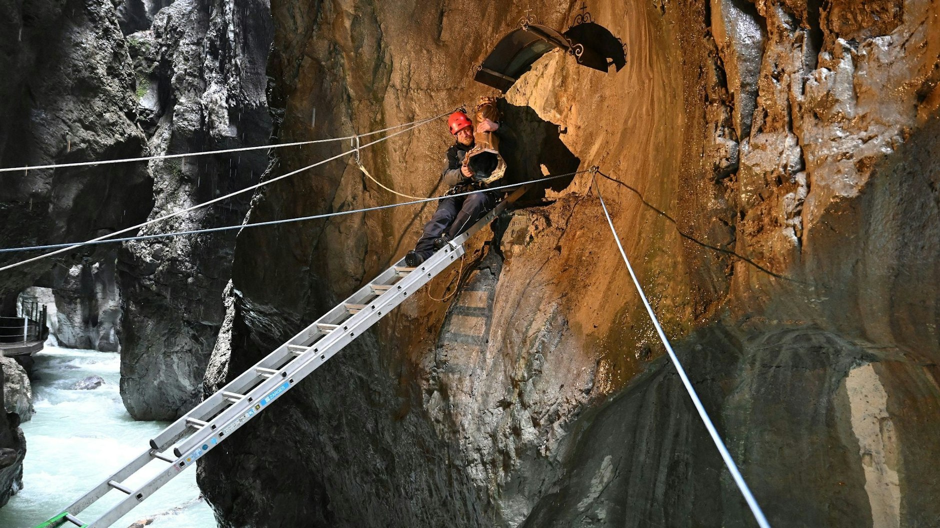 dpatopbilder - Ein Klammwart der Partnachklamm in Garmisch-Partenkirchen bringt die mehr als 100 Jahre alte Madonna nach ihrer Restaurierung an ihren angestammten Platz zurück.