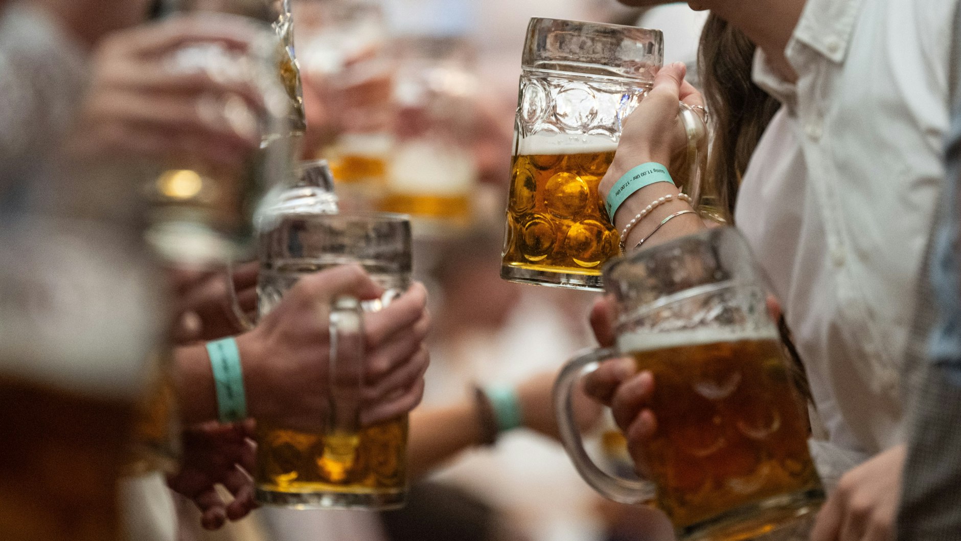 Hohe Ansteckungsgefahr: Besucher haben in einem Festzelt des Stuttgarter Frühlingsfestes Bierkrüge in den Händen.