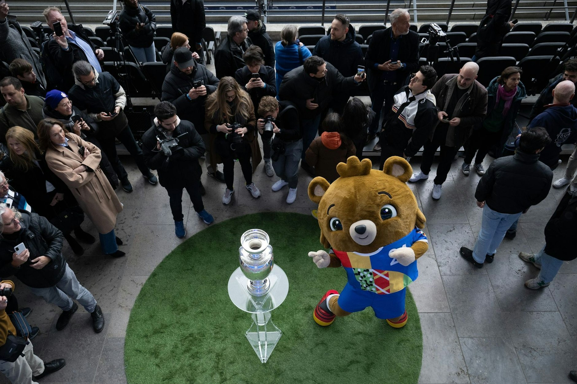 Umringt von Fotografen präsentiert Maskottchen Albärt den EM-Pokal im Berliner Olympiastadion.  