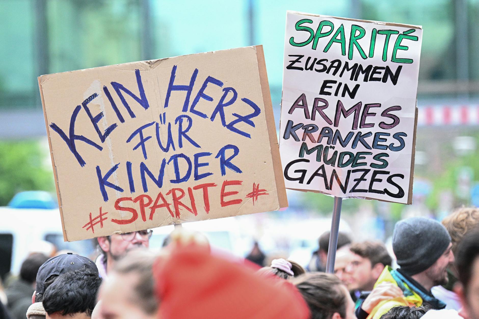 „Kein Herz für Kinder #Sparité “ und „Sparité zusammen ein armes krankes müdes Ganzes“ steht während eines Warnstreiks des Ärzteverbandes Marburger Bund an der Charité auf Schildern.