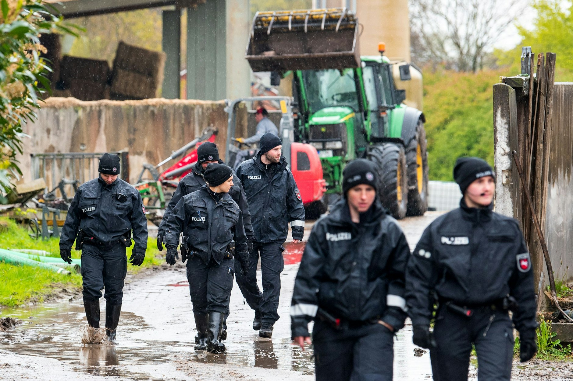 Polizisten gehen auf der Suche nach dem vermissten Arian über ein landwirtschaftliches Gelände.