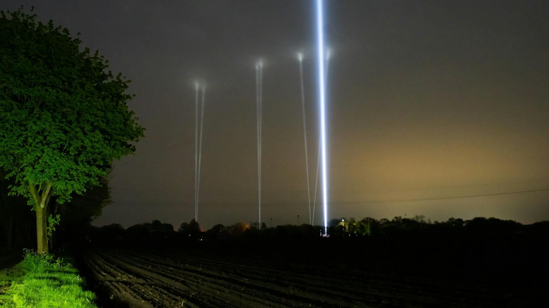 Mehrere Skybeamer leuchten in den Nachthimmel. Bei der Suche nach Arian werden auch Kinderlieder gespielt und Skybeamer eingesetzt, helle Scheinwerfer, die einen Lichtkegel in den Himmel projizieren.