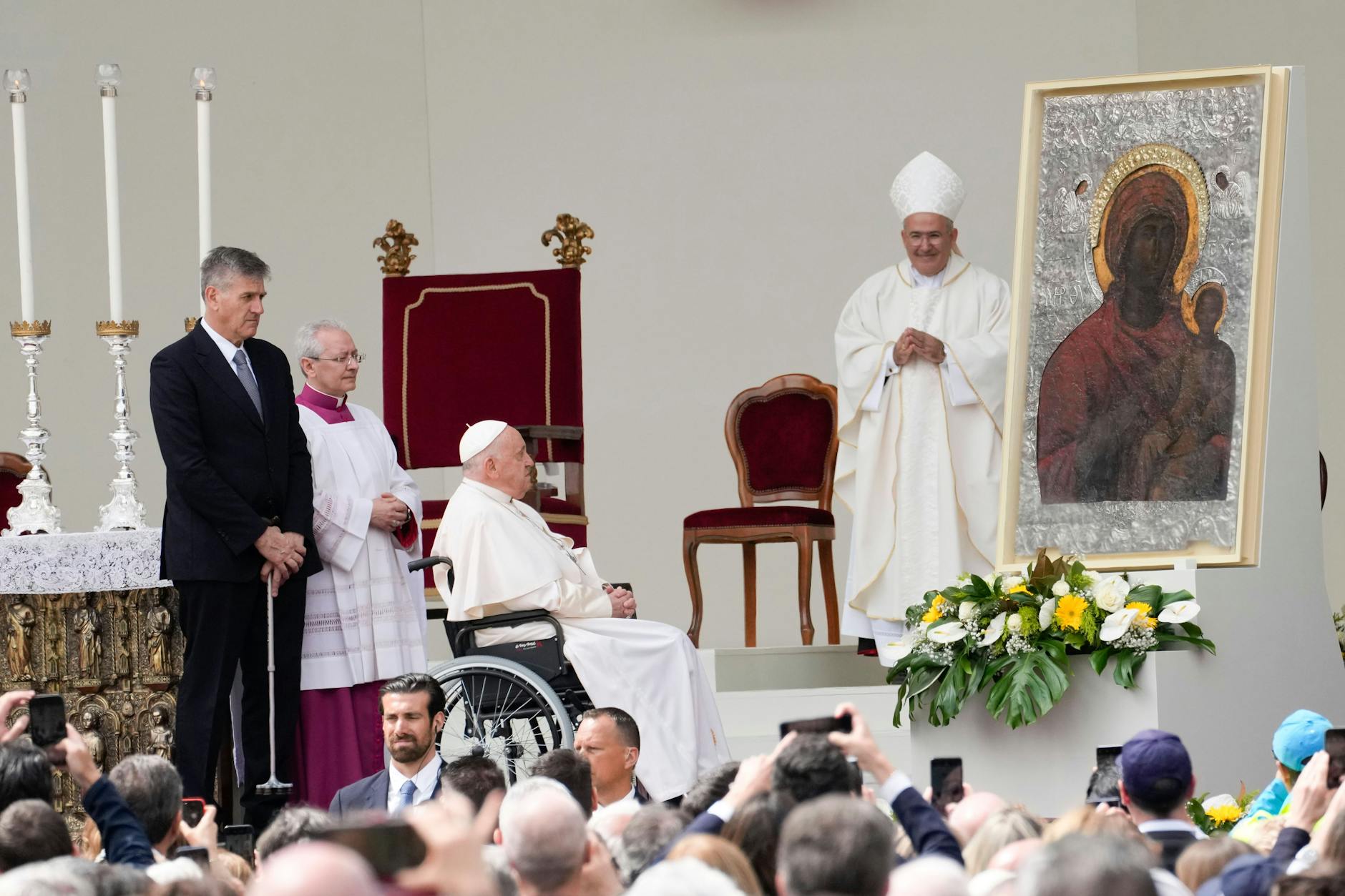 Papst Franziskus im Rollstuhl sitzend betet vor einer Ikone der Jungfrau Maria und Jesuskind am Ende einer Messe auf dem Markusplatz.