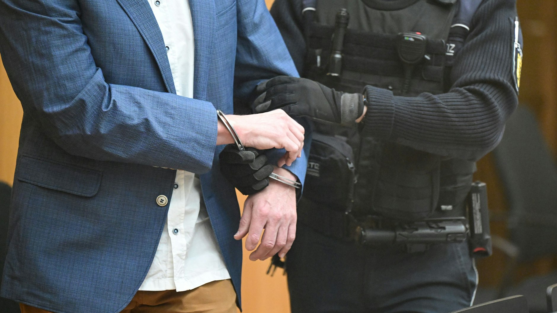 Ein Angeklagter wird in Stuttgart-Stammheim beim Beginn eines Prozesses um Reichsbürger, die mutmaßlich einen Umsturz in Deutschland geplant haben sollen, in den Gerichtssaal geführt. 
