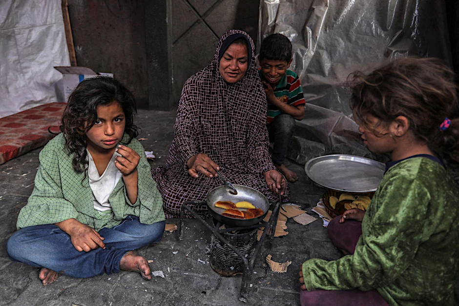 ARCHIV - Eine palästinensische Familie kocht in einem behelfsmäßigen Zelt in Rafah.  