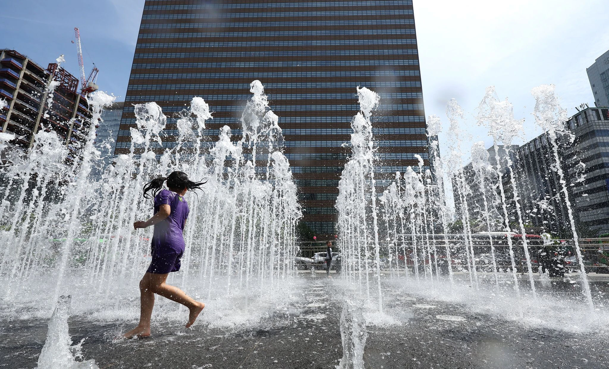 Wasserspaß: Ein Kind spielt bei frühsommerlicher Hitze in einem Springbrunnen in Seoul.  