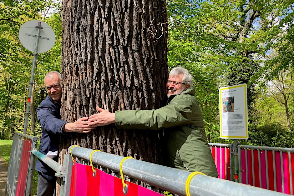 ARCHIV - Agrar- und Umweltminister Axel Vogel (Grüne, rechts) und der Generaldirektor der Stiftung Preußische Schlösser und Gärten Berlin-Brandenburg, Martin Vogtherr, zeigen ein «Herz für Bäume», wie die Station in der Open-Air-Ausstellung «Re:Generation» heißt.  
