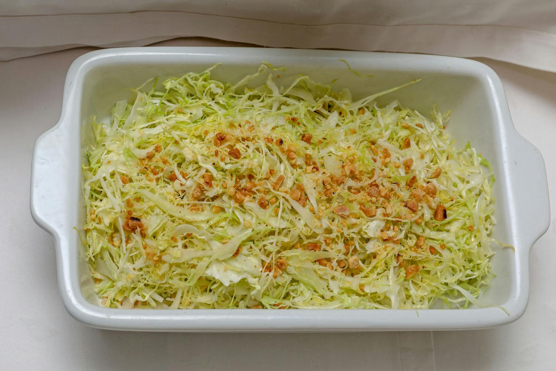 Salzen Sie den Weißkohl! Das ist der Trick für einen wirklich knackigen Pizzasalat. Für eine schöne Farbe und einen etwas süßeren Geschmack können Sie gerne etwas eingelegten Paprikasalat untermischen. Bereiten Sie den Pizzasalat am besten am Vortag zu, um ein optimales Ergebnis zu erzielen.