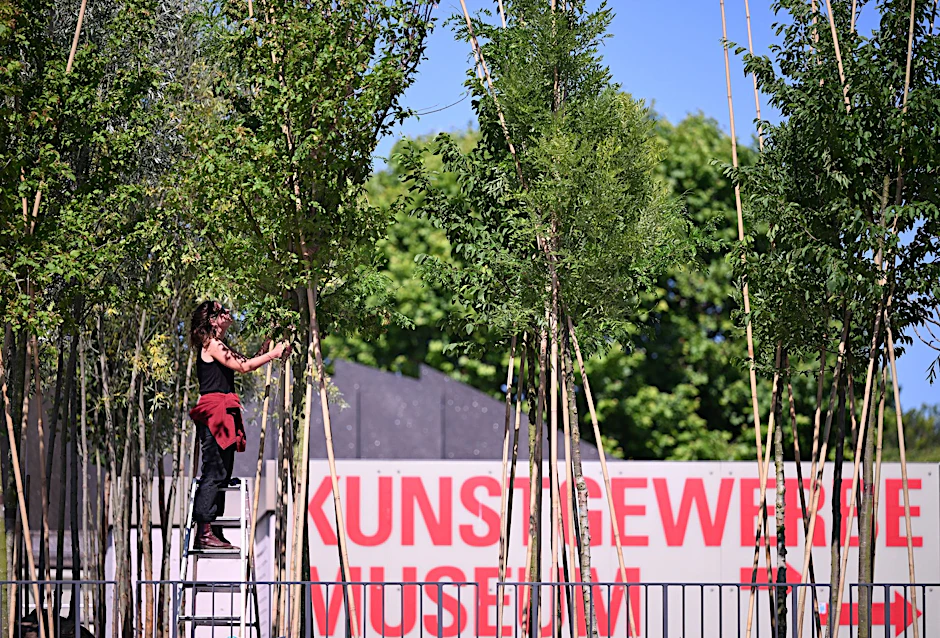 ARCHIV - Eine Mitarbeiterin des atelier le balto beschneidet auf der Piazzetta des Kulturforums im Rahmen der Aktion "Baumschule Kulturforum" junge Laubbäume.  