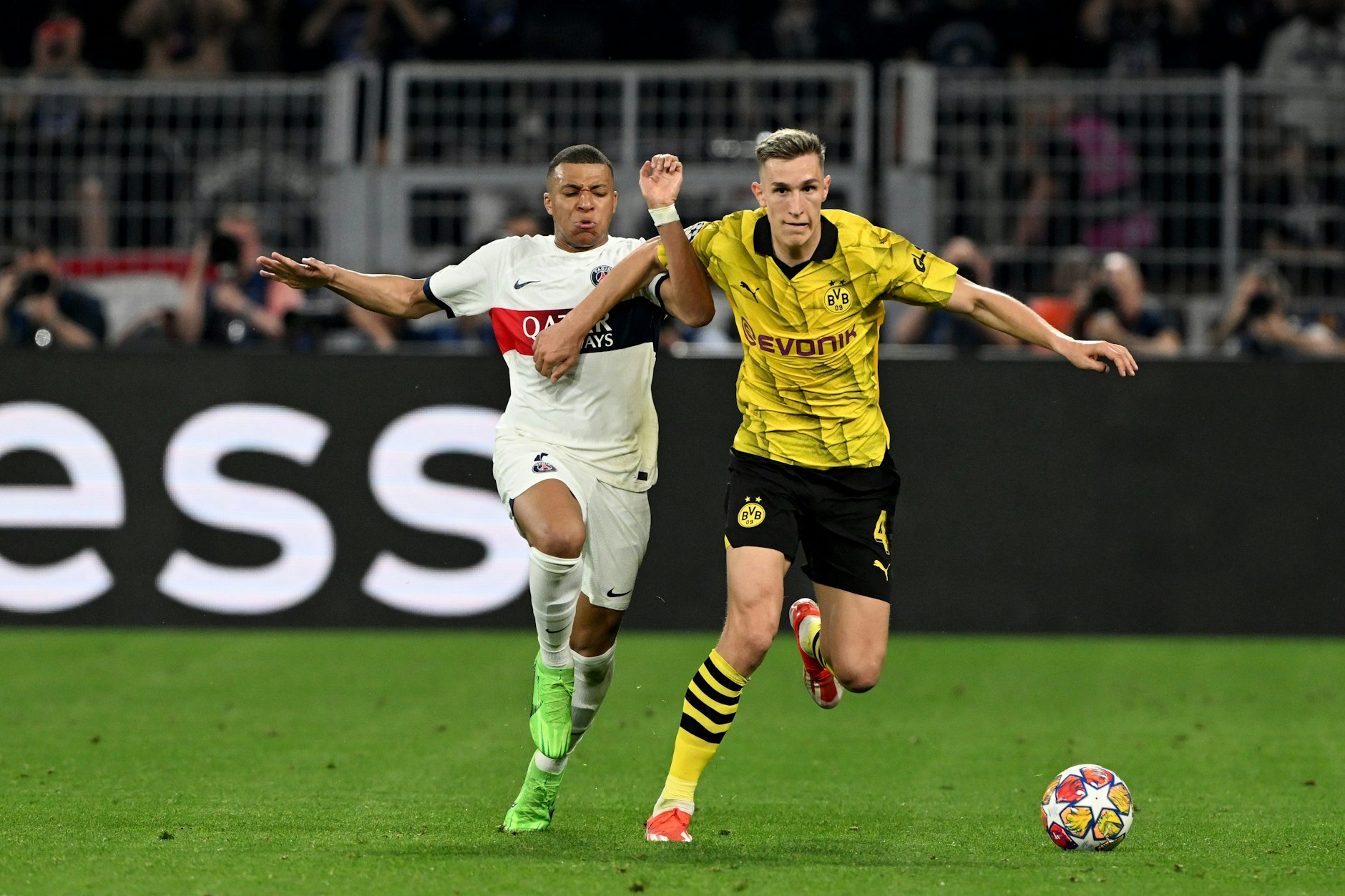 Dortmunds Nico Schlotterbeck (r) und Kylian Mbappe von PSG kämpfen um den Ball.