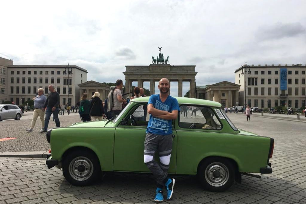 Björn „Paolo“ Petersen vor seinem grünen Trabant am Brandenburger Tor in Berlin.