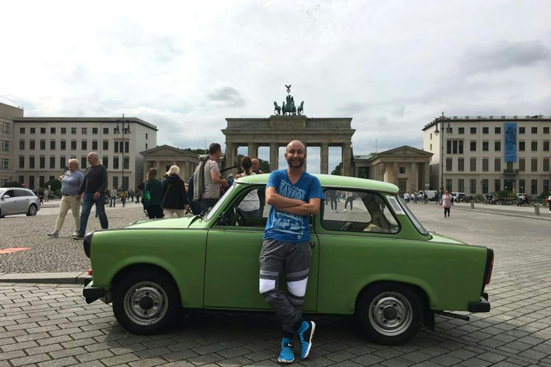 Björn „Paolo“ Petersen vor seinem grünen Trabant am Brandenburger Tor in Berlin.