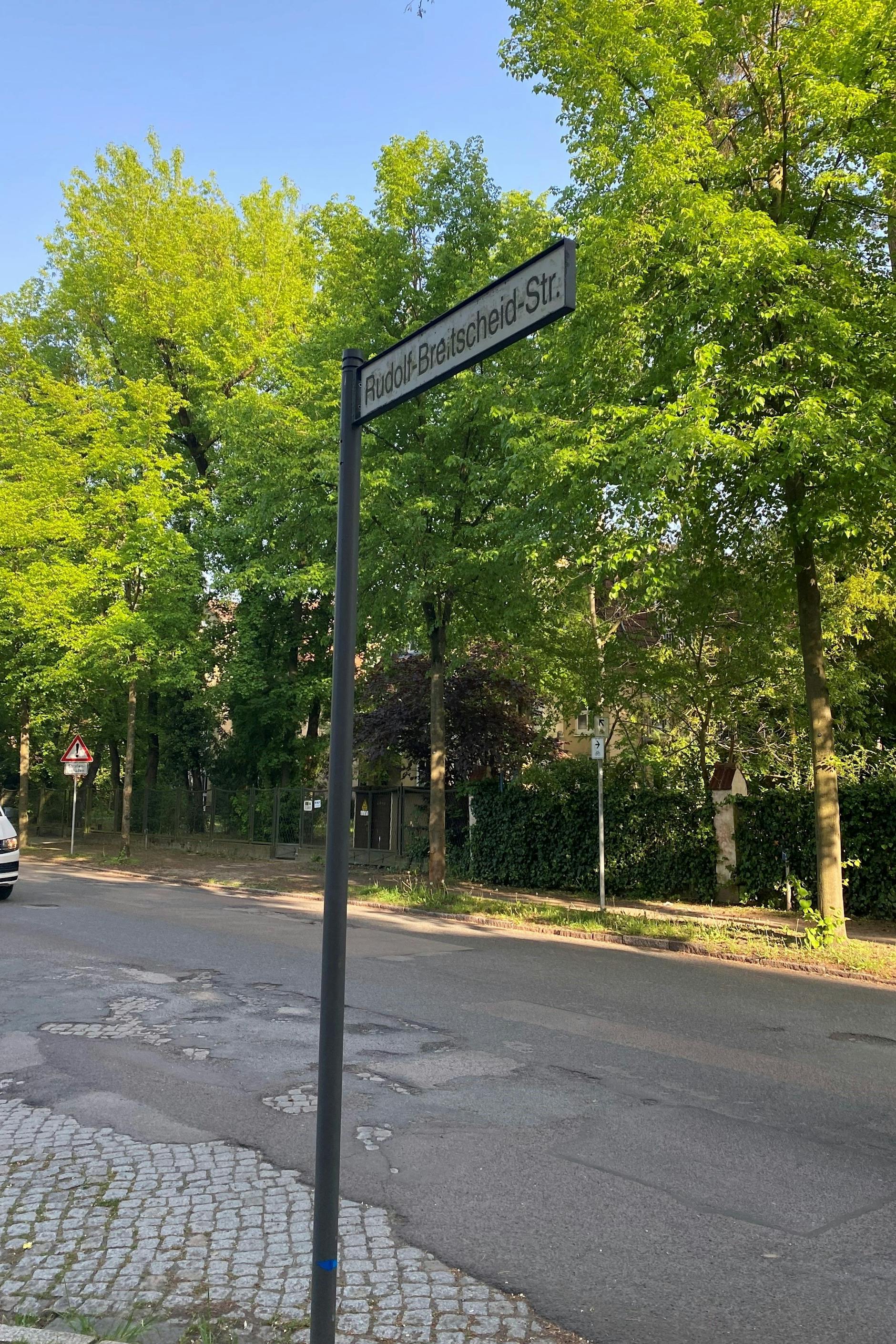 Die Rudolf-Breitscheid-Straße in Potsdam: Sogar unter dem Straßenschild löst sich der Asphalt auf und der DDR-Steinbelag kommt zum Vorschein.
