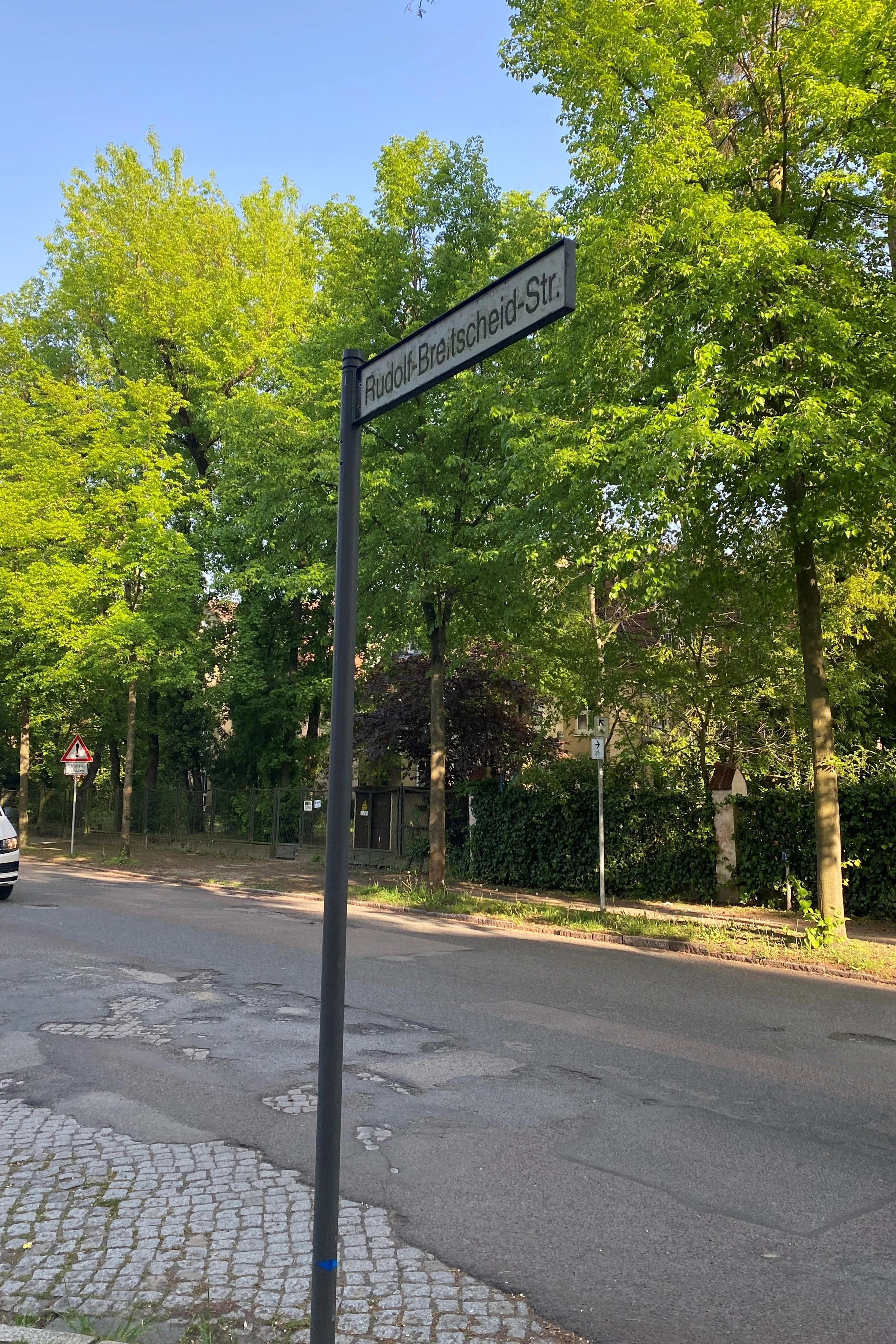Die Rudolf-Breitscheid-Straße in Potsdam: Sogar unter dem Straßenschild löst sich der Asphalt auf und der DDR-Steinbelag kommt zum Vorschein.