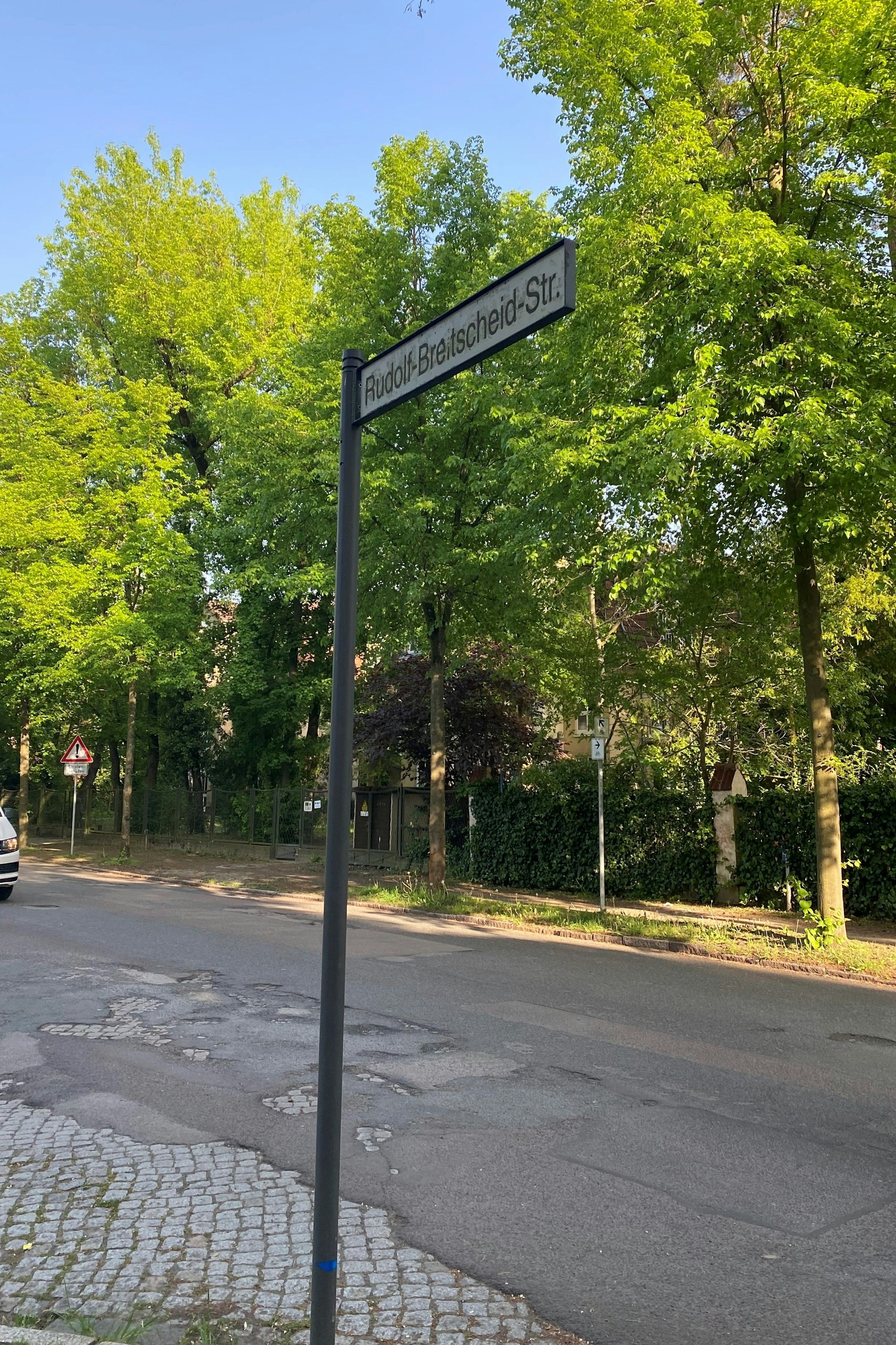 Die Rudolf-Breitscheid-Straße in Potsdam: Sogar unter dem Straßenschild löst sich der Asphalt auf und der DDR-Steinbelag kommt zum Vorschein.