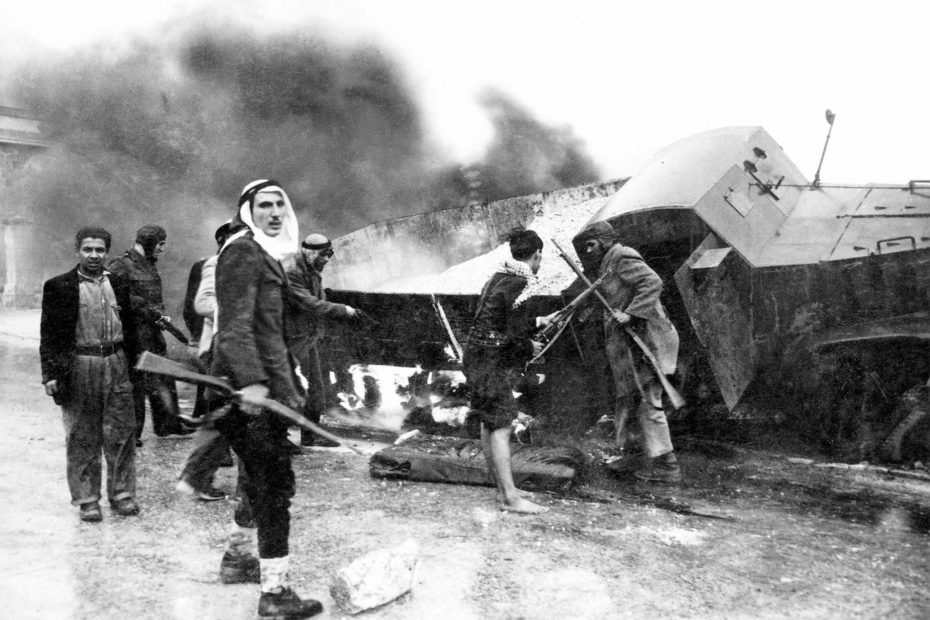 Palästinensische Kämpfer neben einem ausgebrannten Versorgungslastwagen der israelischen Haganah in der Nähe von Jerusalem, Arabisch-Israelischer Krieg, 1948.