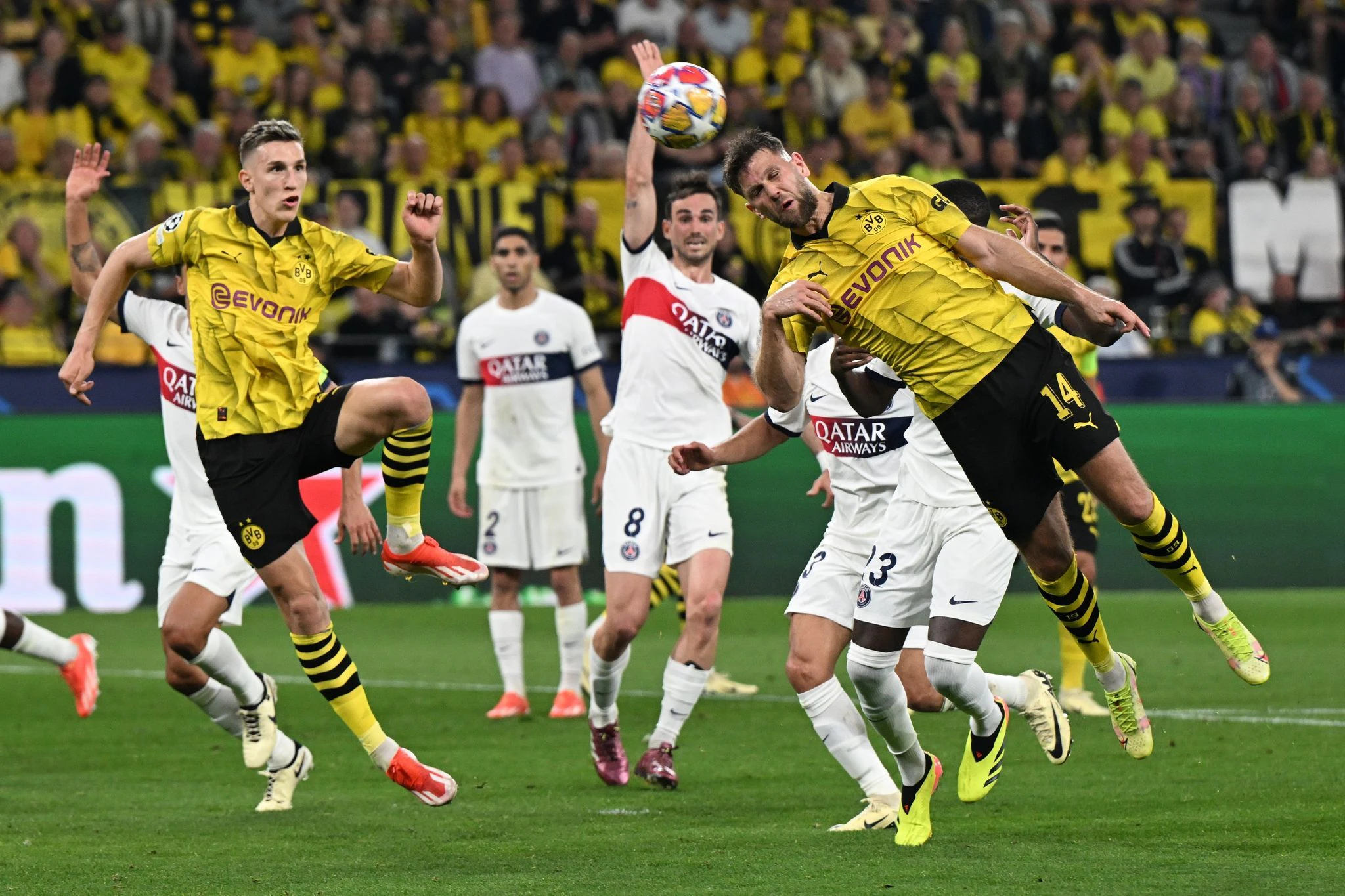 Dortmunds Niclas Füllkrug (r) kommt zum Kopfball - er erziehlt gegen Paris Saint-Germain das entscheidende Tor in der Champions League.  