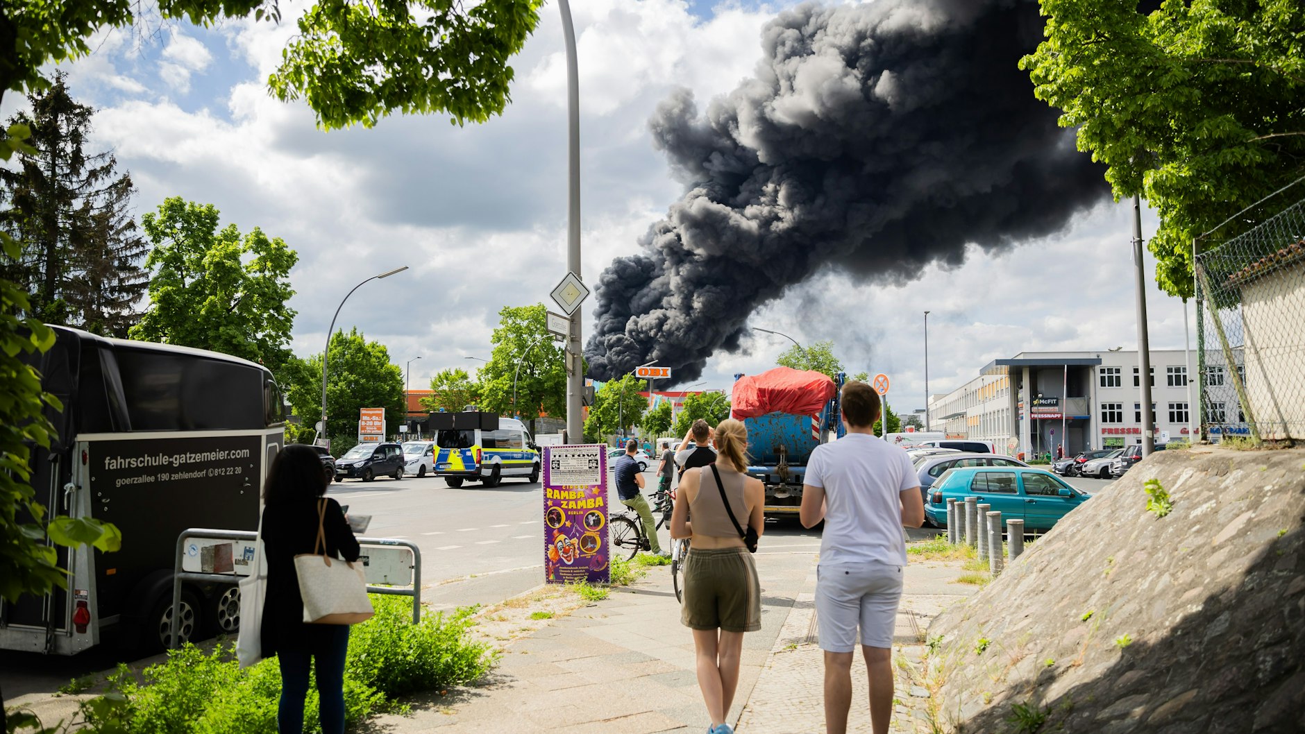Passanten beobachten den Brand in Berlin-Lichterfelde. In einem Betrieb in Berlin-Lichterfelde ist am Freitag ein Feuer ausgebrochen.&nbsp;