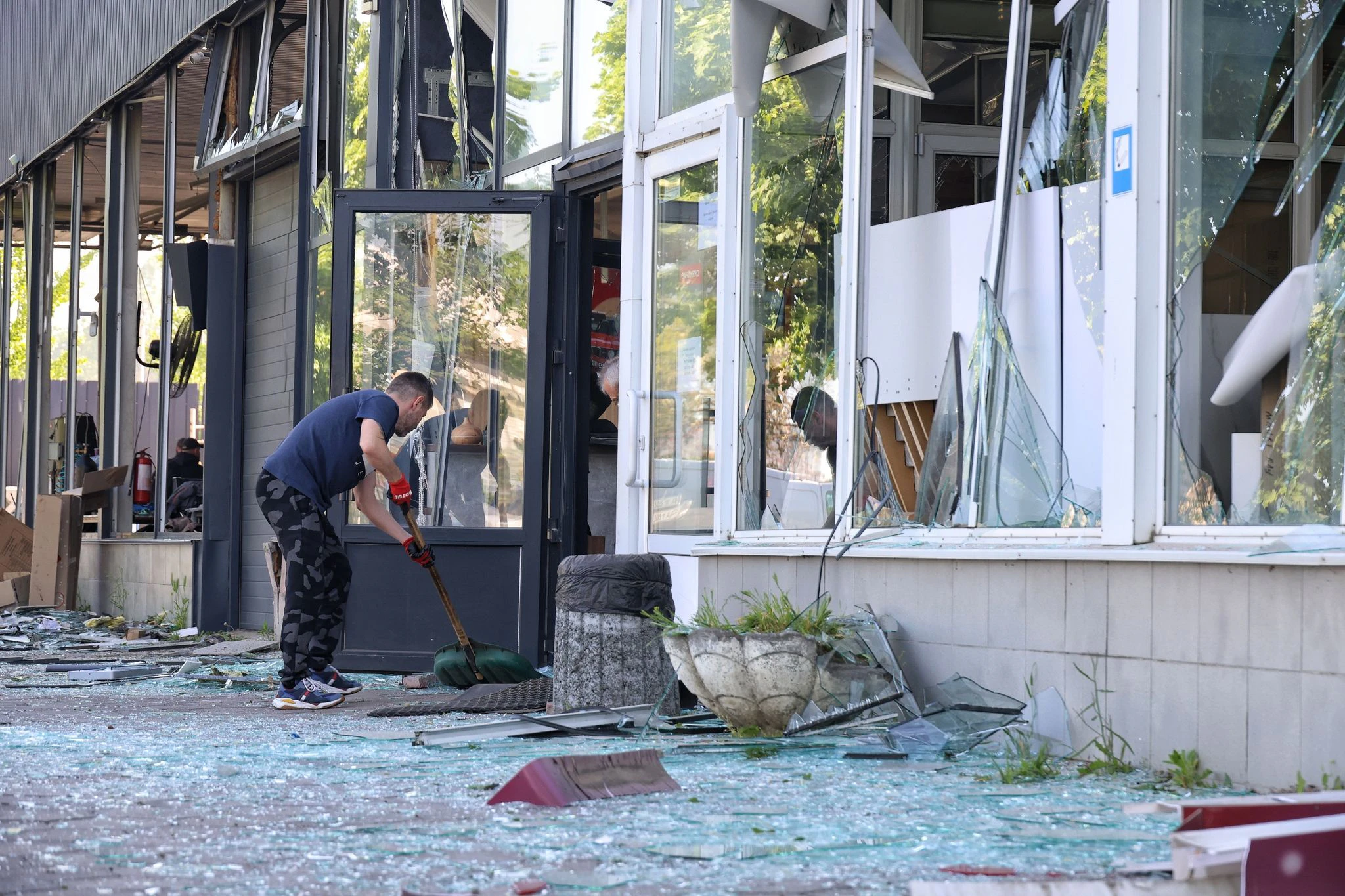 dpatopbilder - Die Spuren der Zerstörung beseitigen: Ein Mann kehrt in Odessa die Glasscherben eines Schaufensters zusammen, das bei einem russischen Raketenangriff zu Bruch gegangen ist.  
