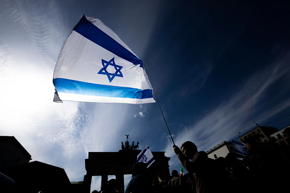 Ein Mann hält bei einer Demonstration in Berlin eine israelische Flagge in der Hand.&nbsp;