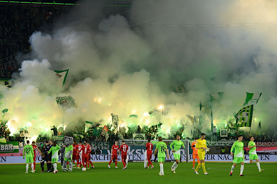 ARCHIV - Auch die Wolfsburger Fans zünden Pyrotechnik.  