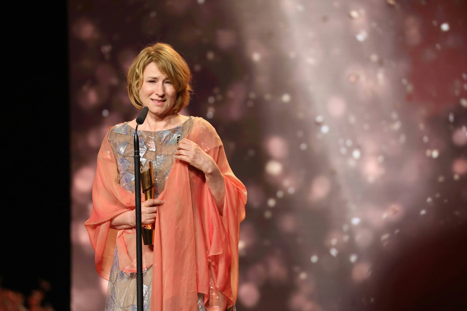 <strong>FLOP:</strong> Liebe <strong>Corinna Harfouch</strong>, nun haben Sie schon vollkommen zu Recht den Preis für die beste Hauptdarstellerin in „Sterben“ bekommen und noch immer zaubert Ihnen das kein Lächeln auf die Lippen. Liegt es vielleicht daran, dass Sie Ihren romantischen Schlafzimmervorhang umgelegt haben, damit Sie im Saal nicht bibbern müssen? Gut, jetzt haben Sie den Preis ja und können schnell ins Warme.