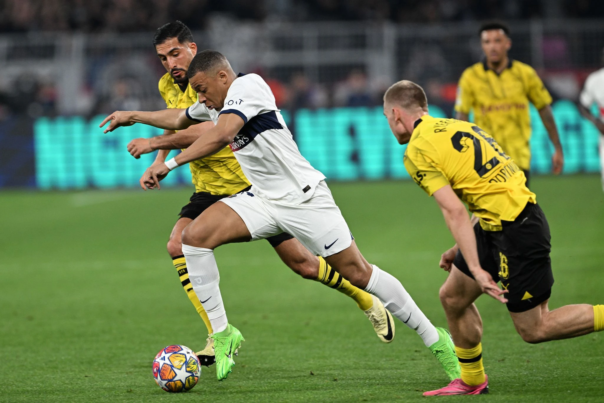 PSG-Superstar Kylian Mbappé (M) im Laufduell mit Emre Can (l) und Julian Ryerson.  