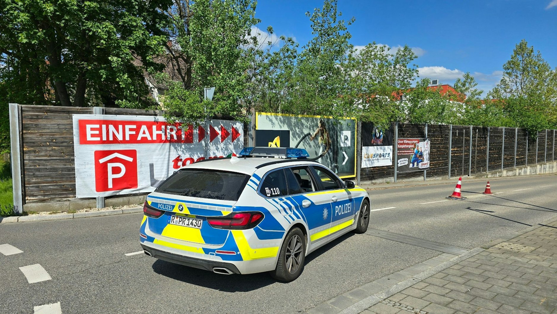 Ein Polizeiauto steht in der Zufahrt zur Tiefgarage eines Baumarkts, wo die Leiche einer Frau im Kofferraum eines Autos gefunden wurde.