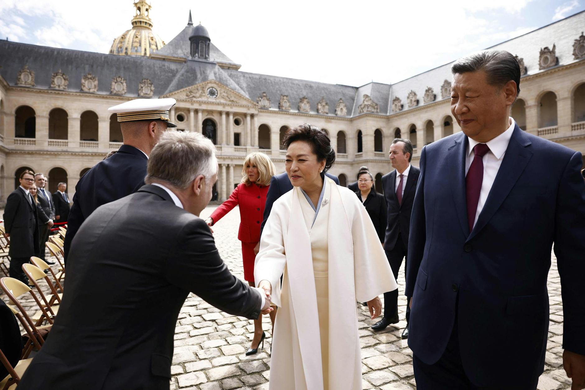Der chinesische Präsident Xi Jinping (r.) und seine Frau Peng Liyuan (M.) zu Beginn ihres zweitägigen Staatsbesuchs in Frankreich