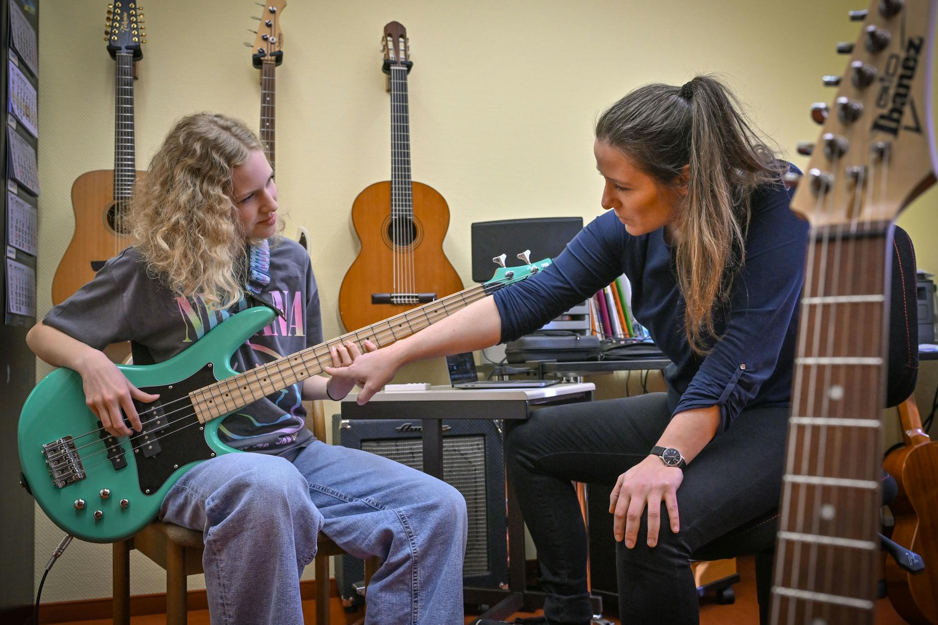 Die Schülerin Juno Bennewitz (l.) übt E-Bass an der Städtischen Musikschule Johann Crüger und wird dabei von ihrer Lehrerin Ramona Geißler unterstützt.
