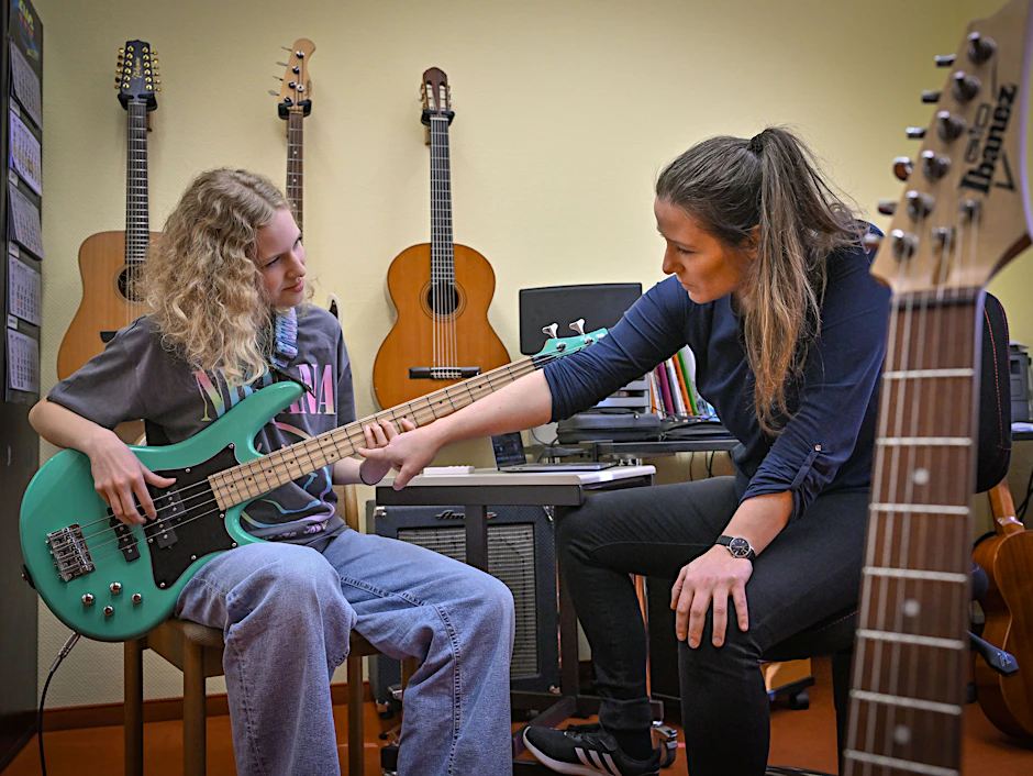 Die Schülerin Juno Bennewitz (l.) übt E-Bass an der Städtischen Musikschule Johann Crüger und wird dabei von ihrer Lehrerin Ramona Geißler unterstützt.