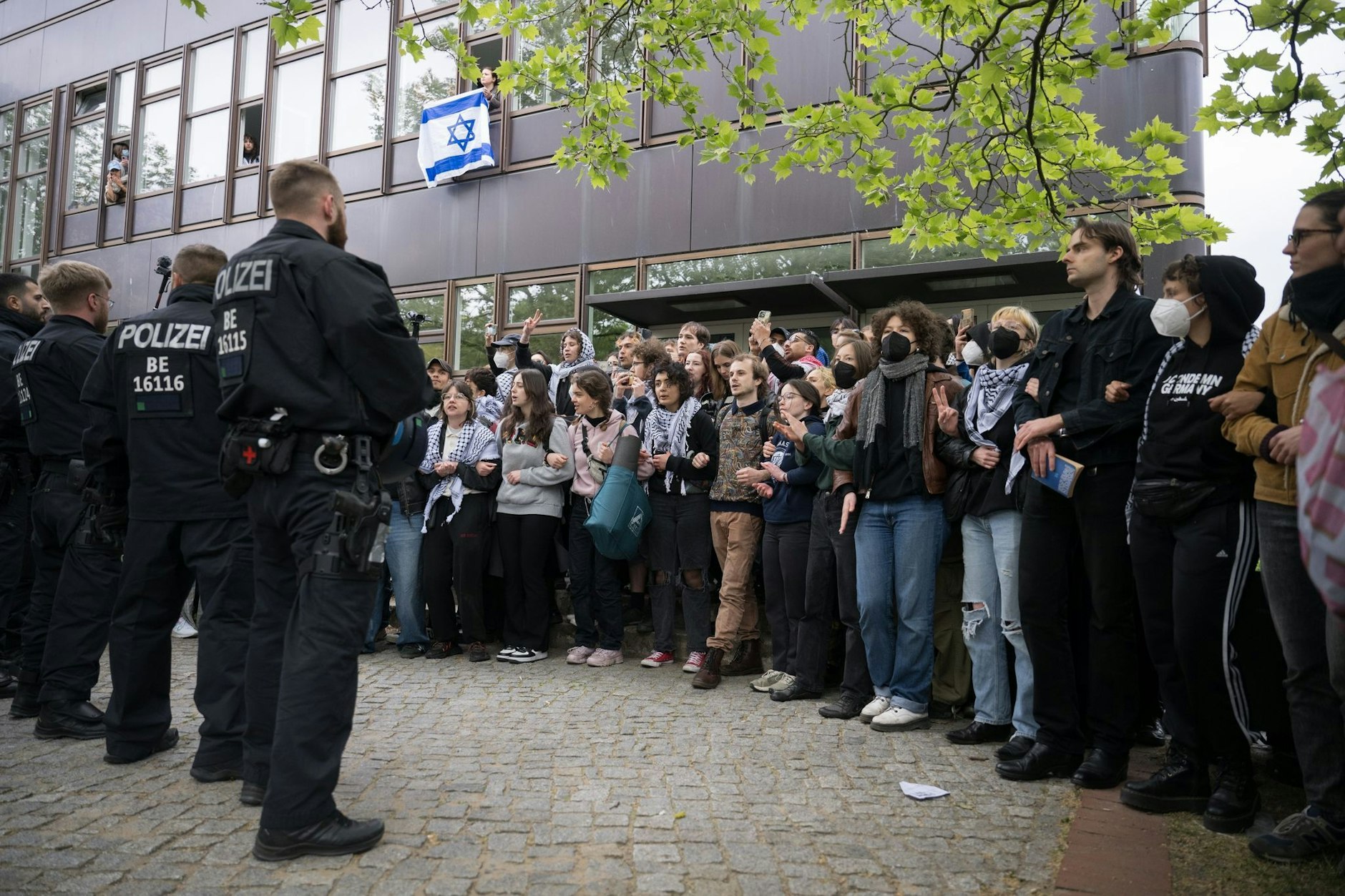dpatopbilder - Polizei und Protestierende der propalästinensischen Gruppe «Student Coalition Berlin» stehen sich bei einer Demonstation auf dem Theaterhof der Freien Universität Berlin gegenüber.