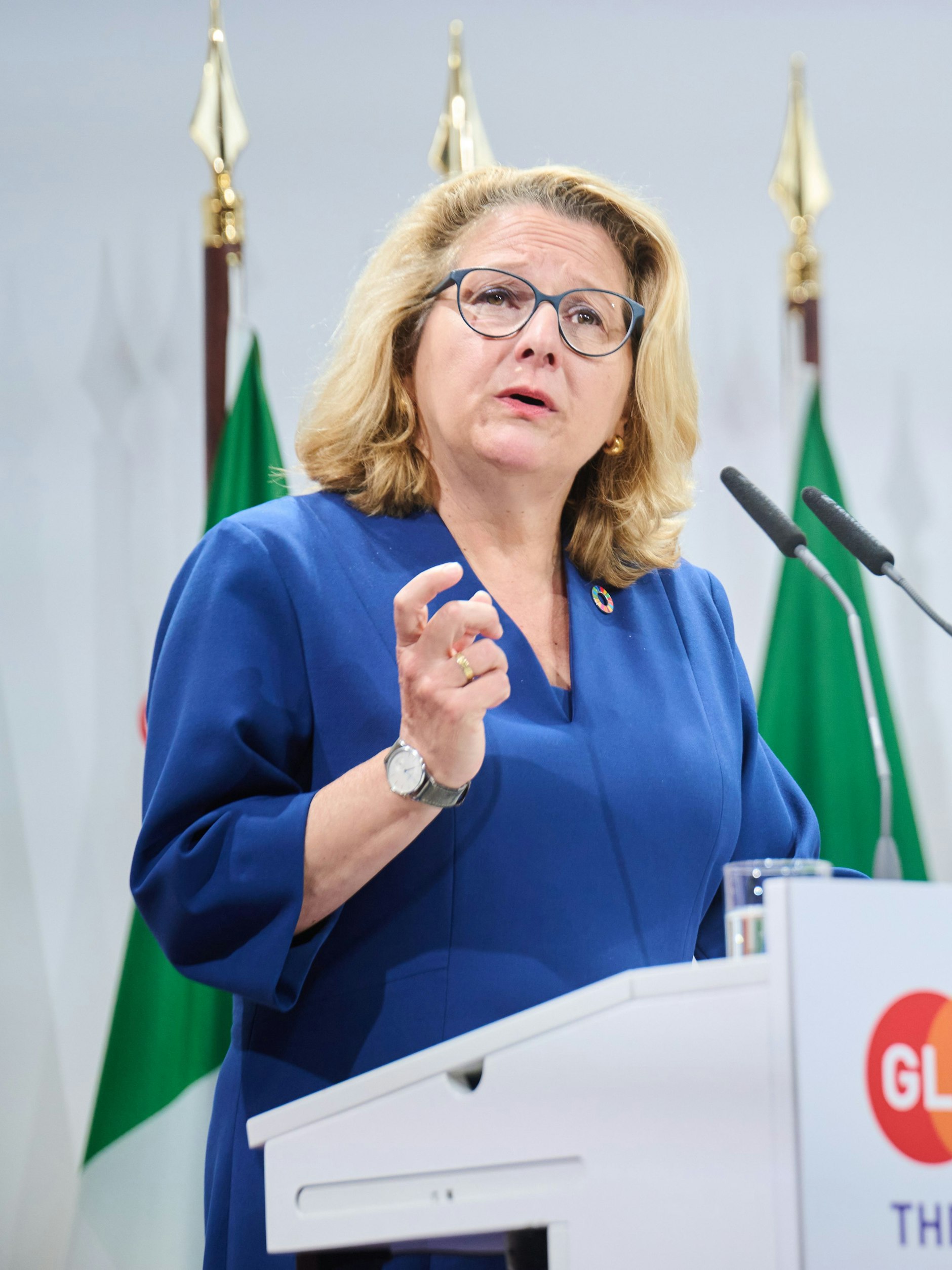 Auch die Bundesministerin für wirtschaftliche Zusammenarbeit und Entwicklung, <strong>Svenja Schulze</strong>, legte einen zwar wenig spannenden, aber doch soliden modischen Auftrag hin: Ein blaues Kleid mit tiefem V-Ausschnitt und Wiener Nähten, dazu chunky goldene Ohrringe und die Haare locker offen getragen – so wird’s gemacht! Gut sind auch die mittellangen, weiten Ärmel, die eine gewisse hemdsärmelige Geschäftigkeit suggerieren.