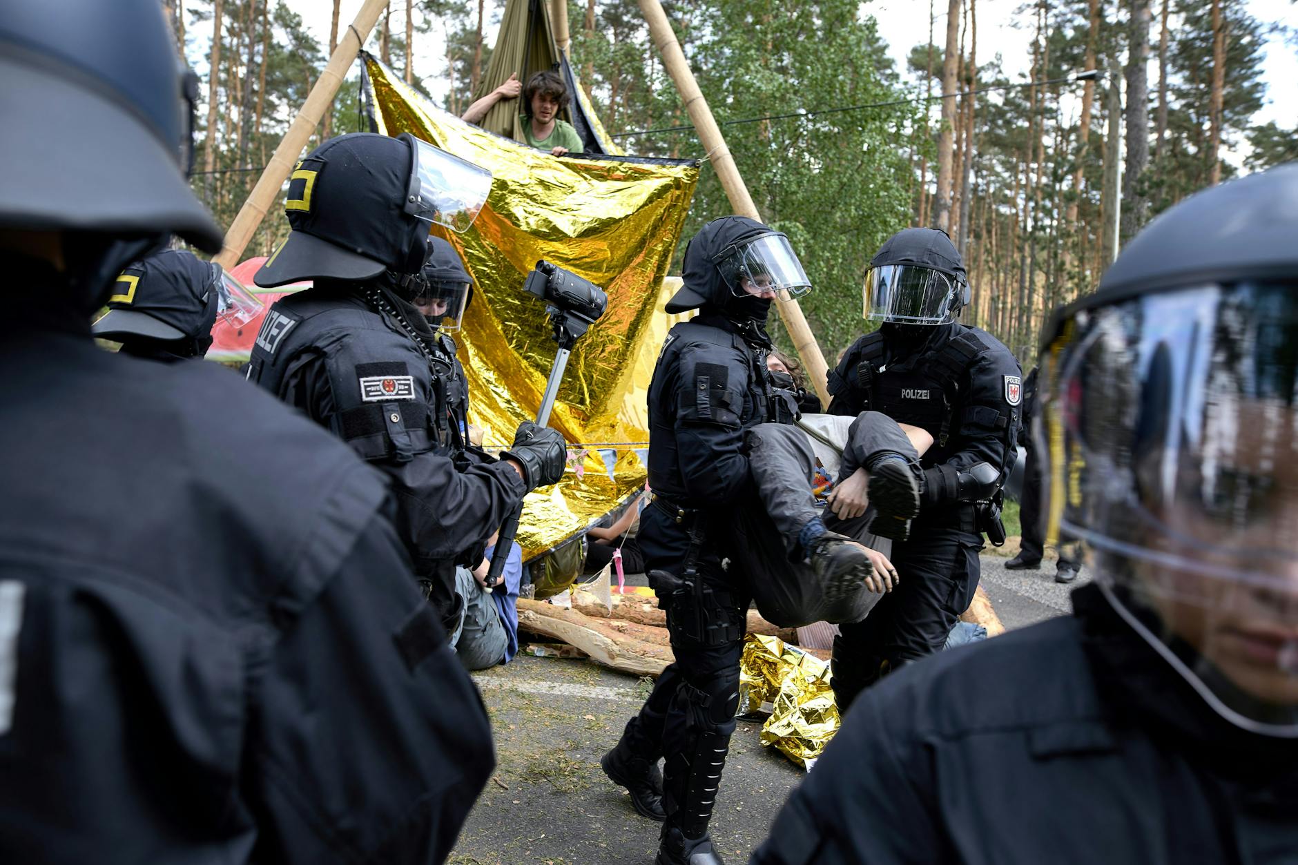 Polizei räumt Aktivisten von einer Straßenblockade bei einer Protestaktion gegen Tesla. Aktivisten haben versucht, auf das Werksgelände in Grünheide vorzudringen.