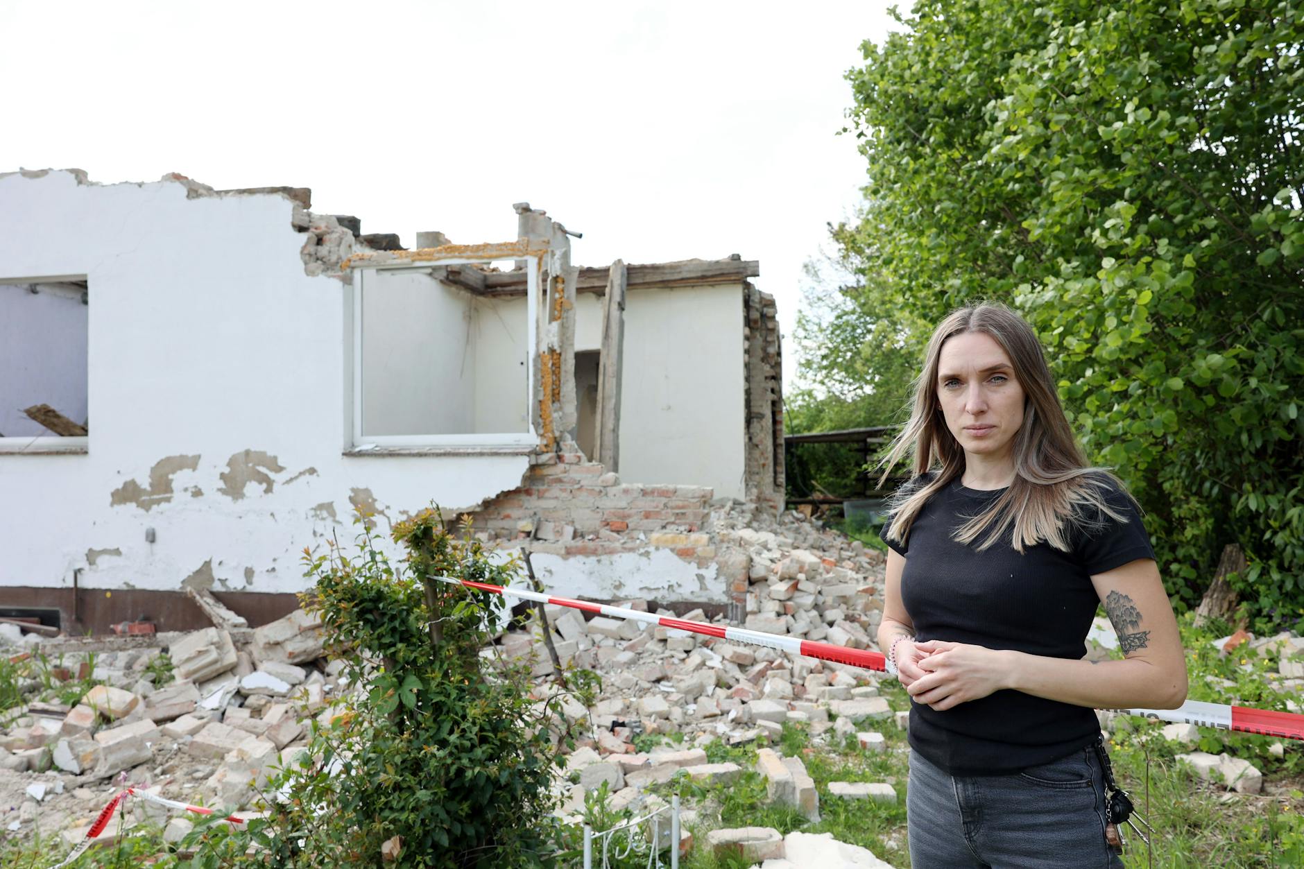 Anika S. vor der Ruine des alten Gebäudes. Bei den Abrissarbeiten verletzte sich ihr Mann schwer und ist seitdem querschnittgelähmt.