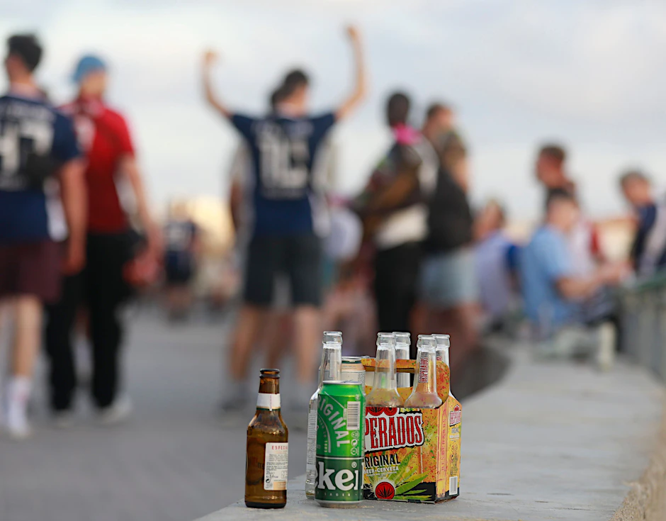 Menschen feiern an der Promenade am Strand von El Arenal. Alkoholkonsum auf der Straße wird verboten.