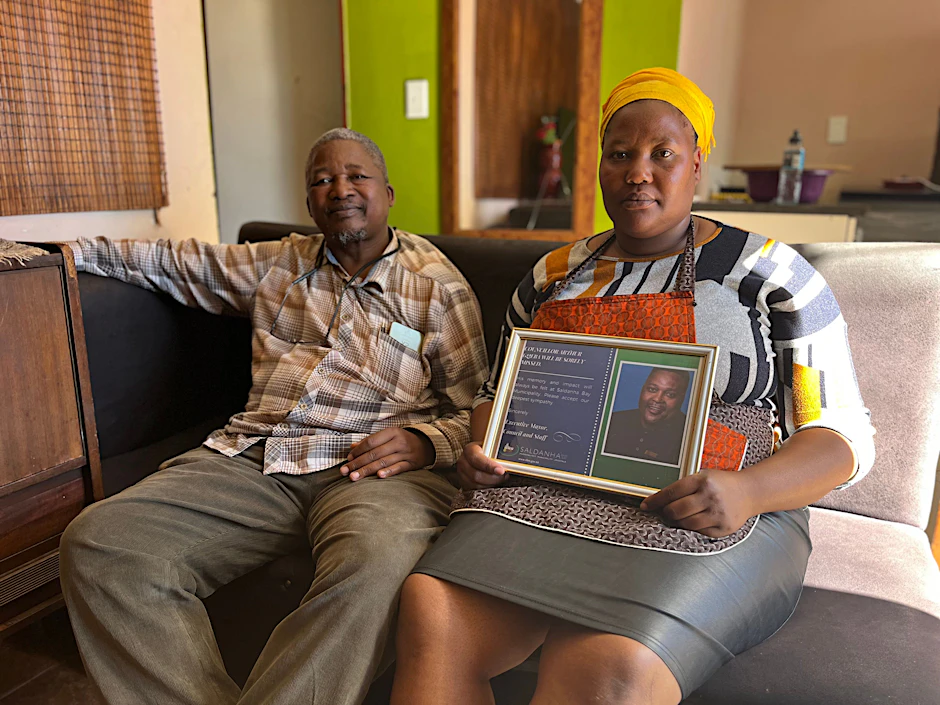 Arthur Gqebas Witwe Ntombekhaya und sein Onkel Vivid Mgoqi mit einem gerahmten Foto des ermordeten Lokalpolitikers.