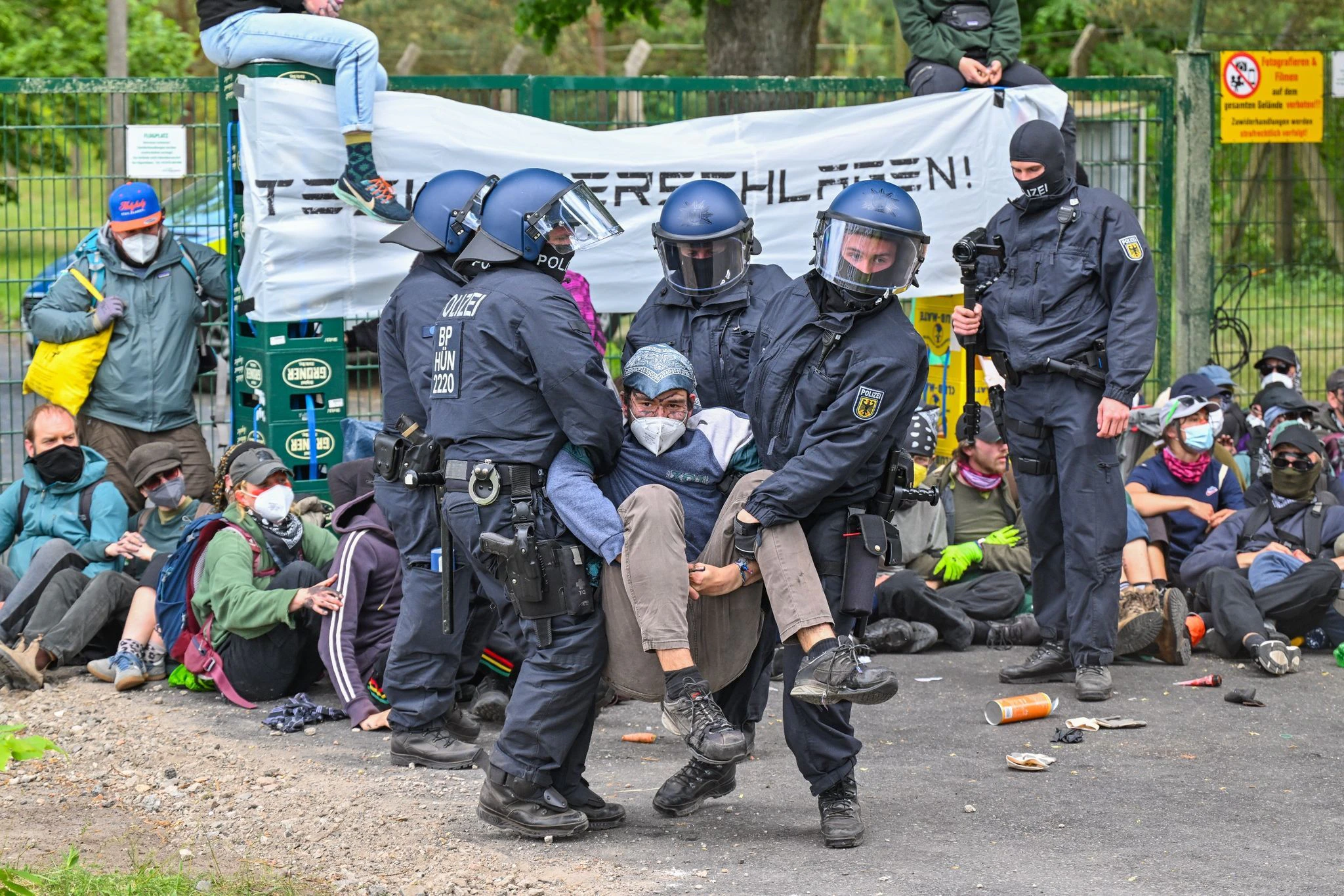 dpatopbilder - Polizisten räumen eine Blockade von Aktivisten an der Zufahrt zum Flugplatz Neuhardenberg. Auf dem Gelände werden Fahrzeuge von Tesla zwischengelagert, die im Werk in Grünheide produziert wurden.  