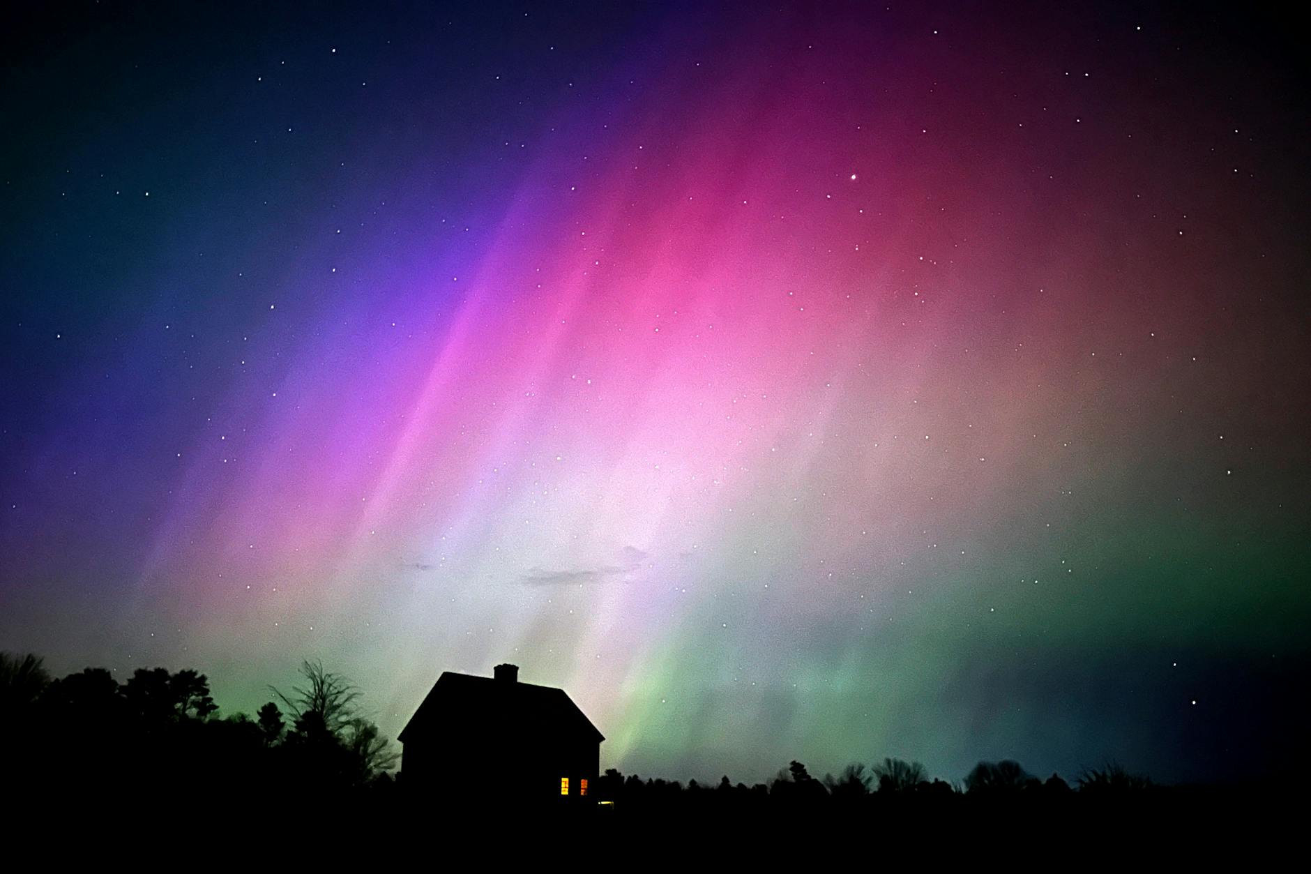 Polarlichter erscheinen am Himmel über einem Bauernhaus in den USA.