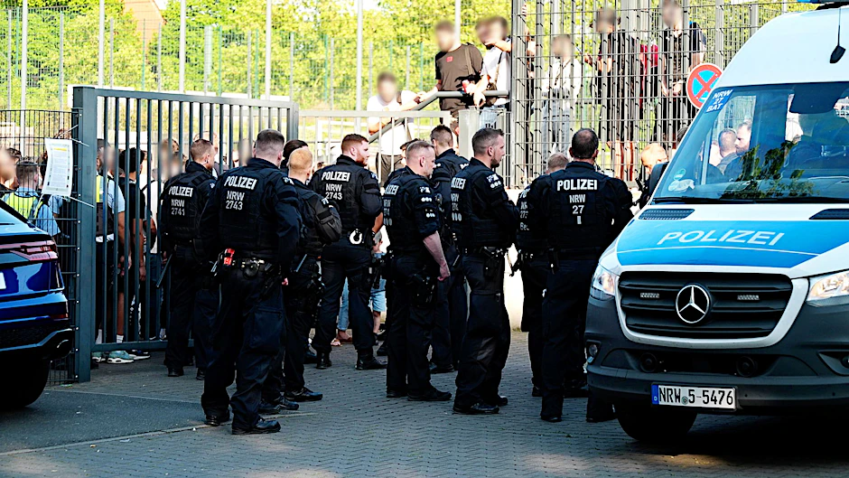 Einsatzkräfte der Polizei stehen vor der Bezirkssportanlage Bäuminghausstraße in Essen.
