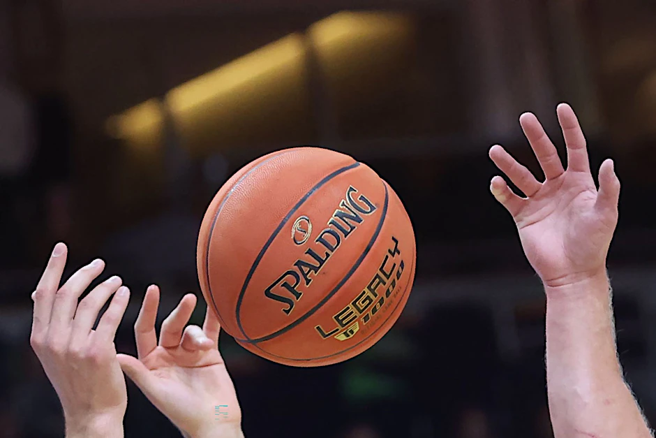 Spieler greifen nach einem Basketball.  