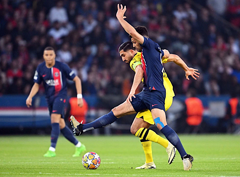 Dortmunds Emre Can und Goncalo Ramos (vorne) von Paris kämpfen um den Ball.  