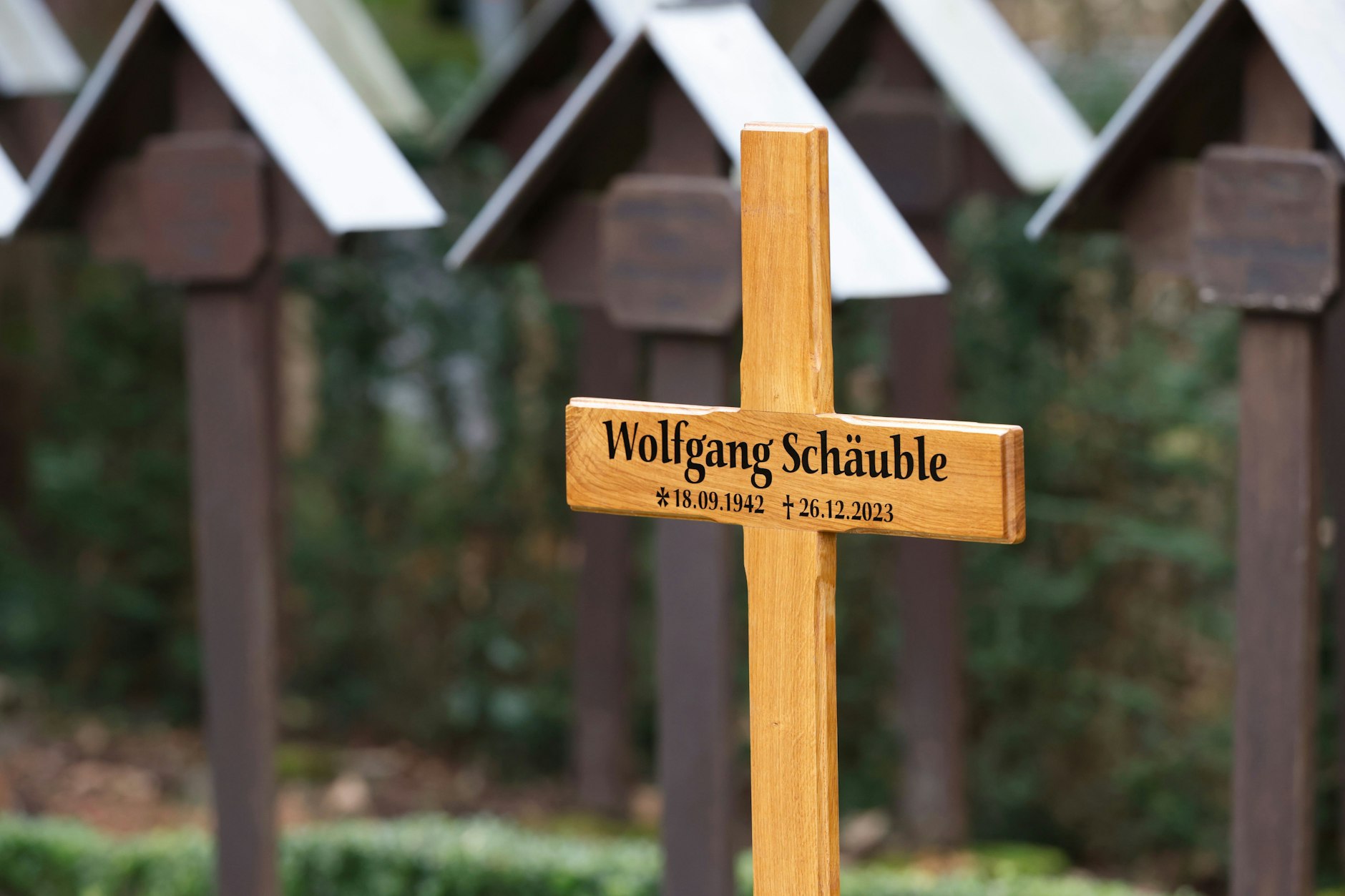 Ein Kreuz kennzeichnet am Rande der Trauerfeier für Wolfgang Schäuble die Grabstätte auf dem Friedhof.